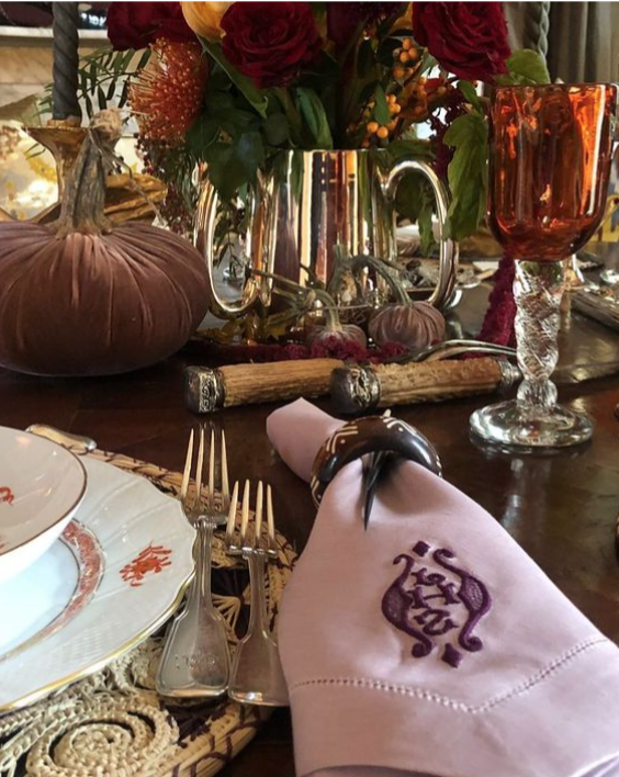 Monogrammed linen napkin with polished silver flatware on a Thanksgiving table.*
